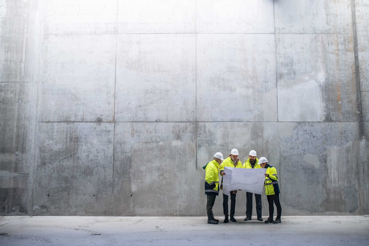 Construction site team reviewing project plans on a tablet